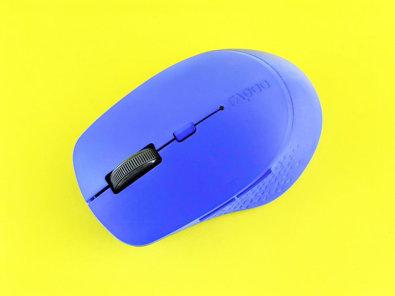 Stylish blue wireless computer mouse placed on a vivid yellow background for contrast and appeal.
